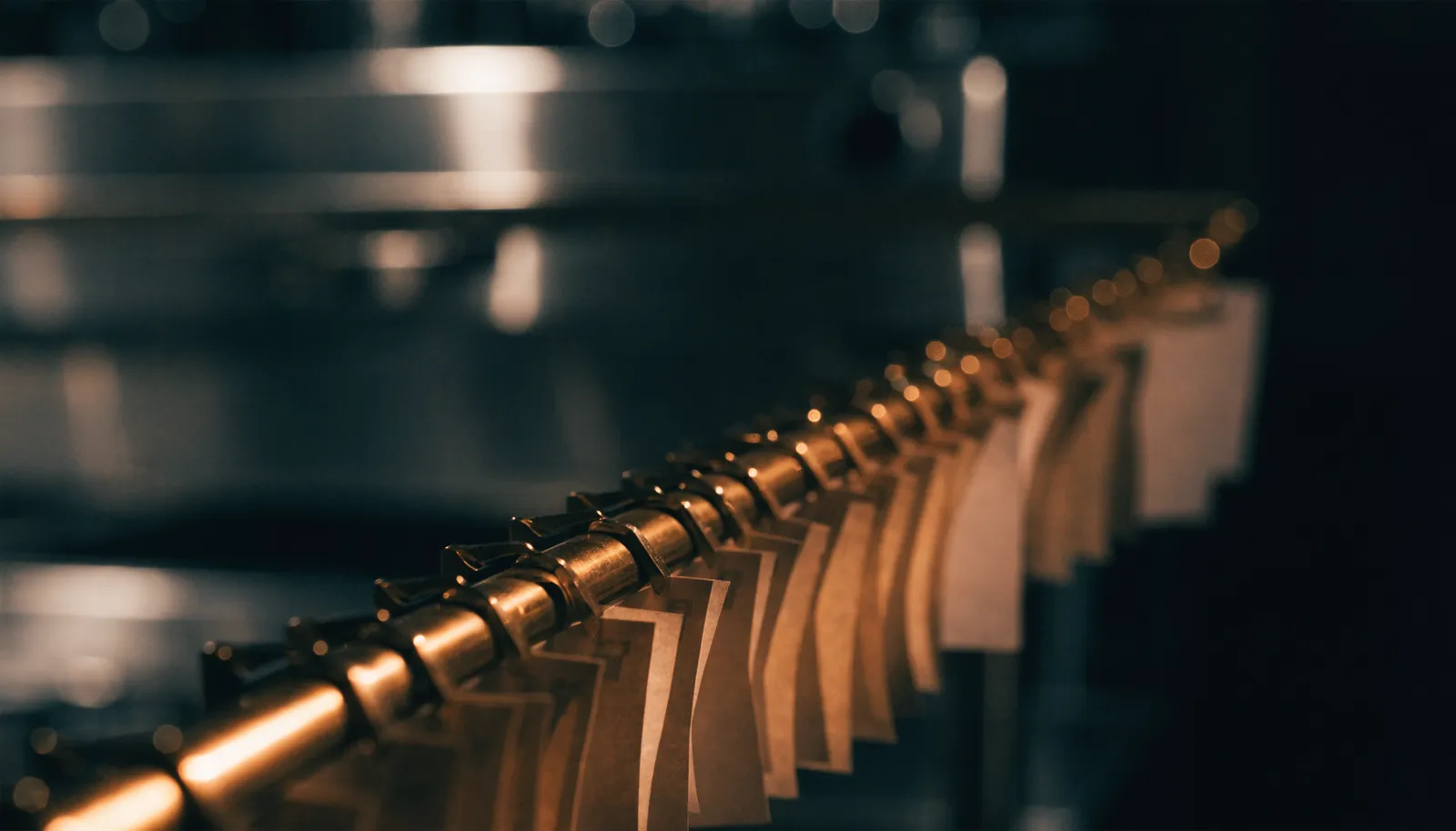 Blank tickets clipped along a brass rail in a dark kitchen